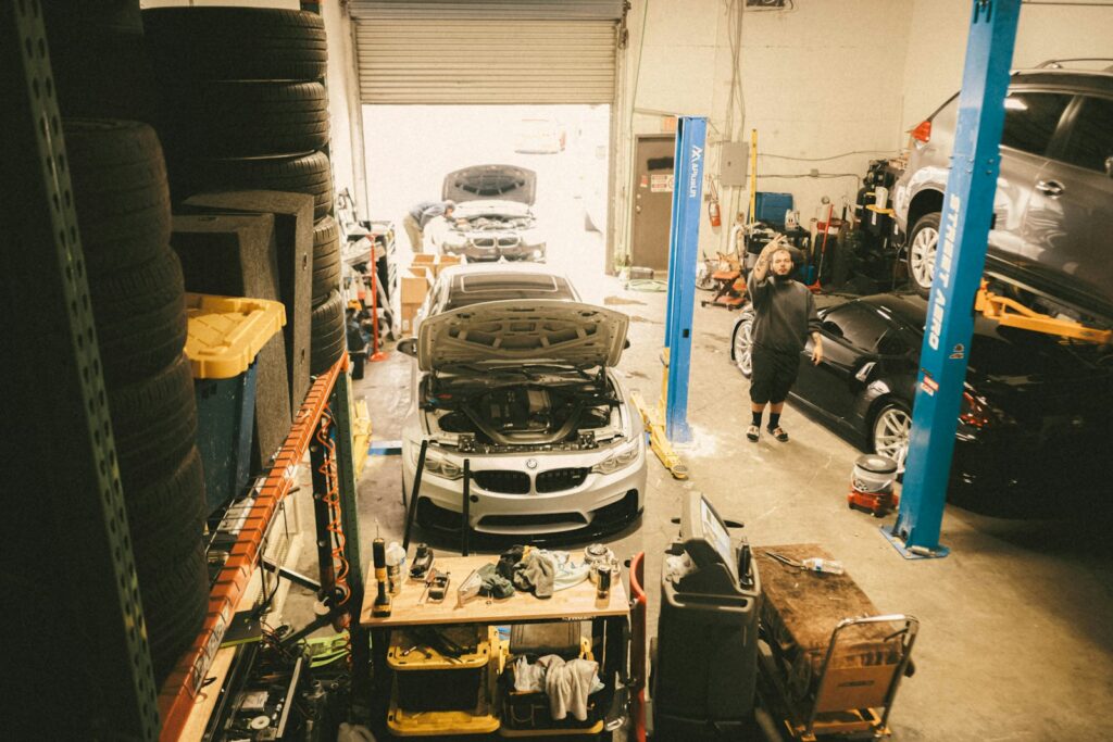 A car in a garage being worked on by a mechanic