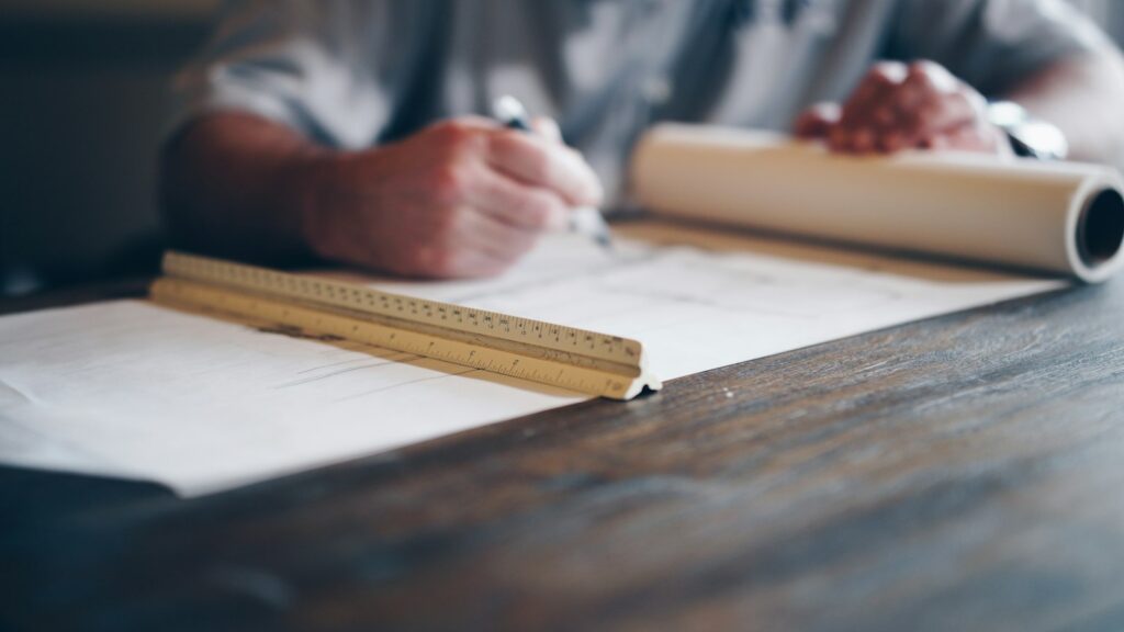 Person drafting on blueprint