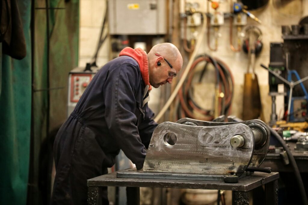 A man working on a metal object in a shop