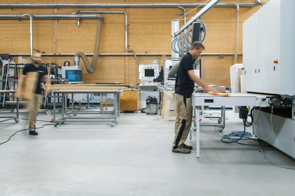 Woman in black shirt and gray pants standing near white table