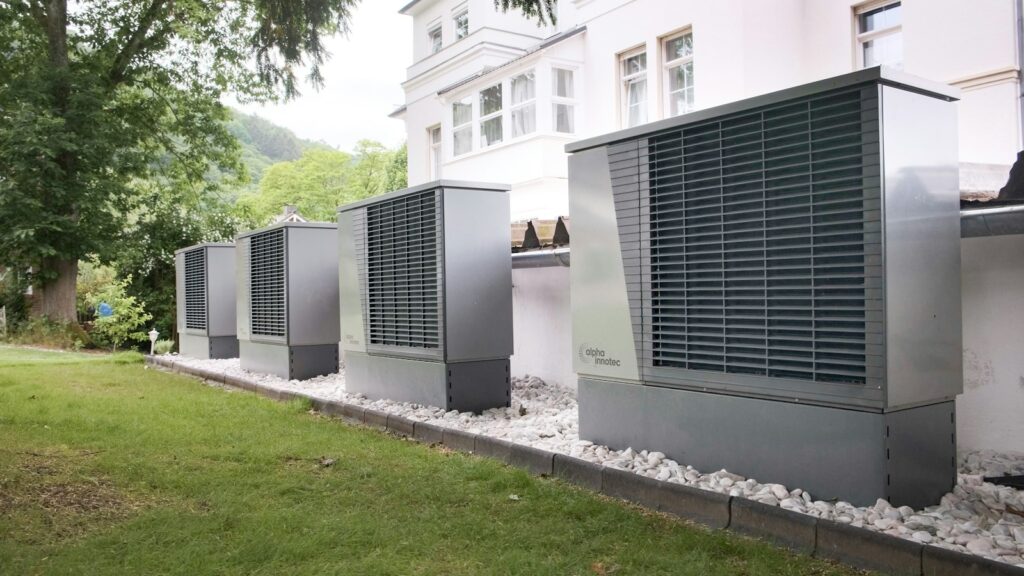 Four industrial air conditioning units lined up outside building