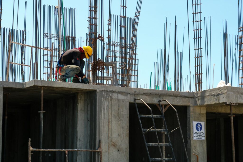 Man kneeling on unfinished building during daytime