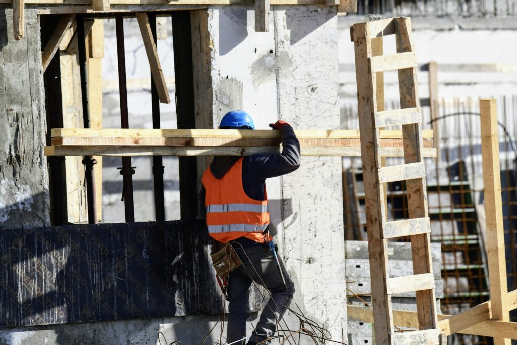 A construction worker is working on the side of a building